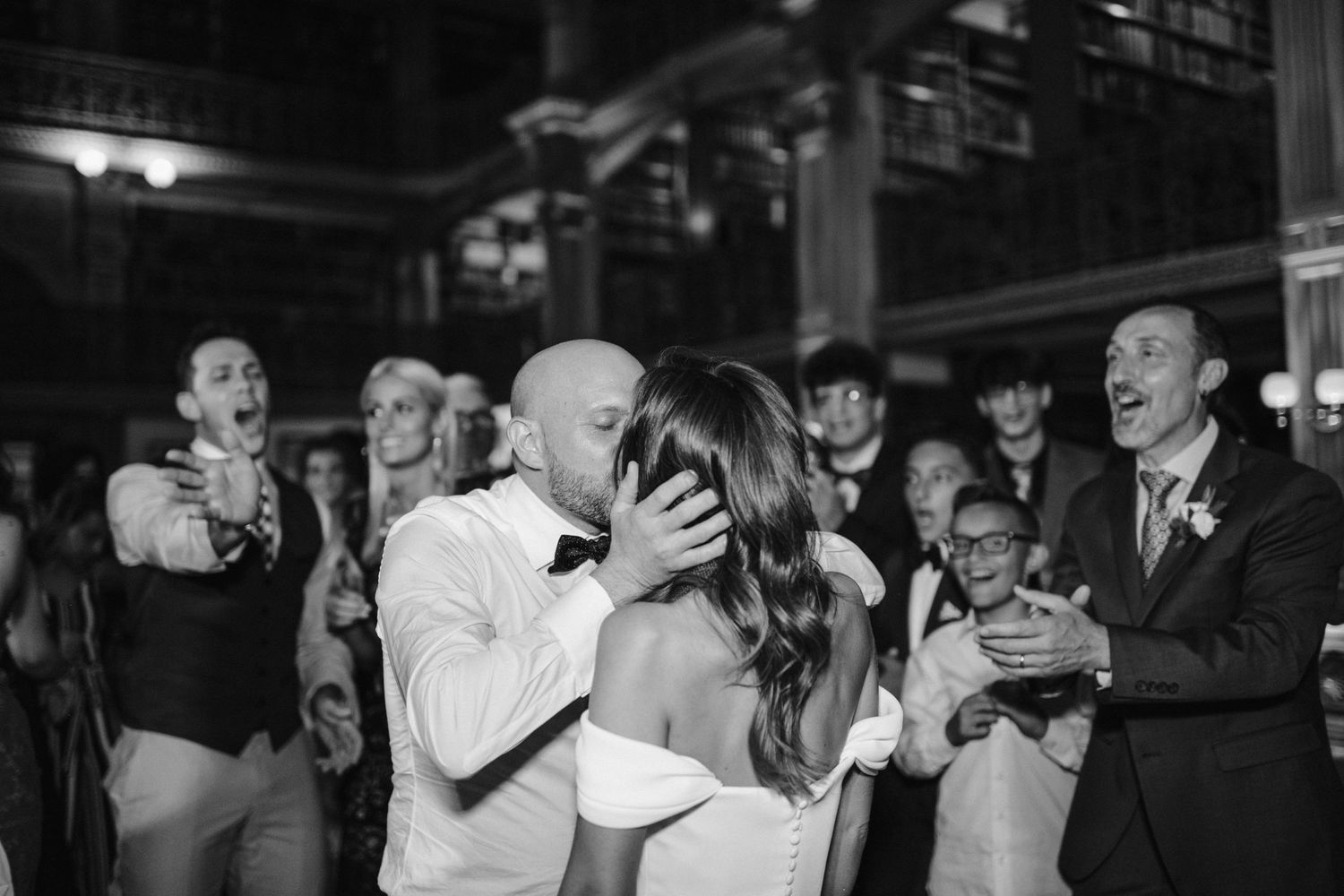 A couple shares a romantic kiss on the dance floor during their wedding reception.