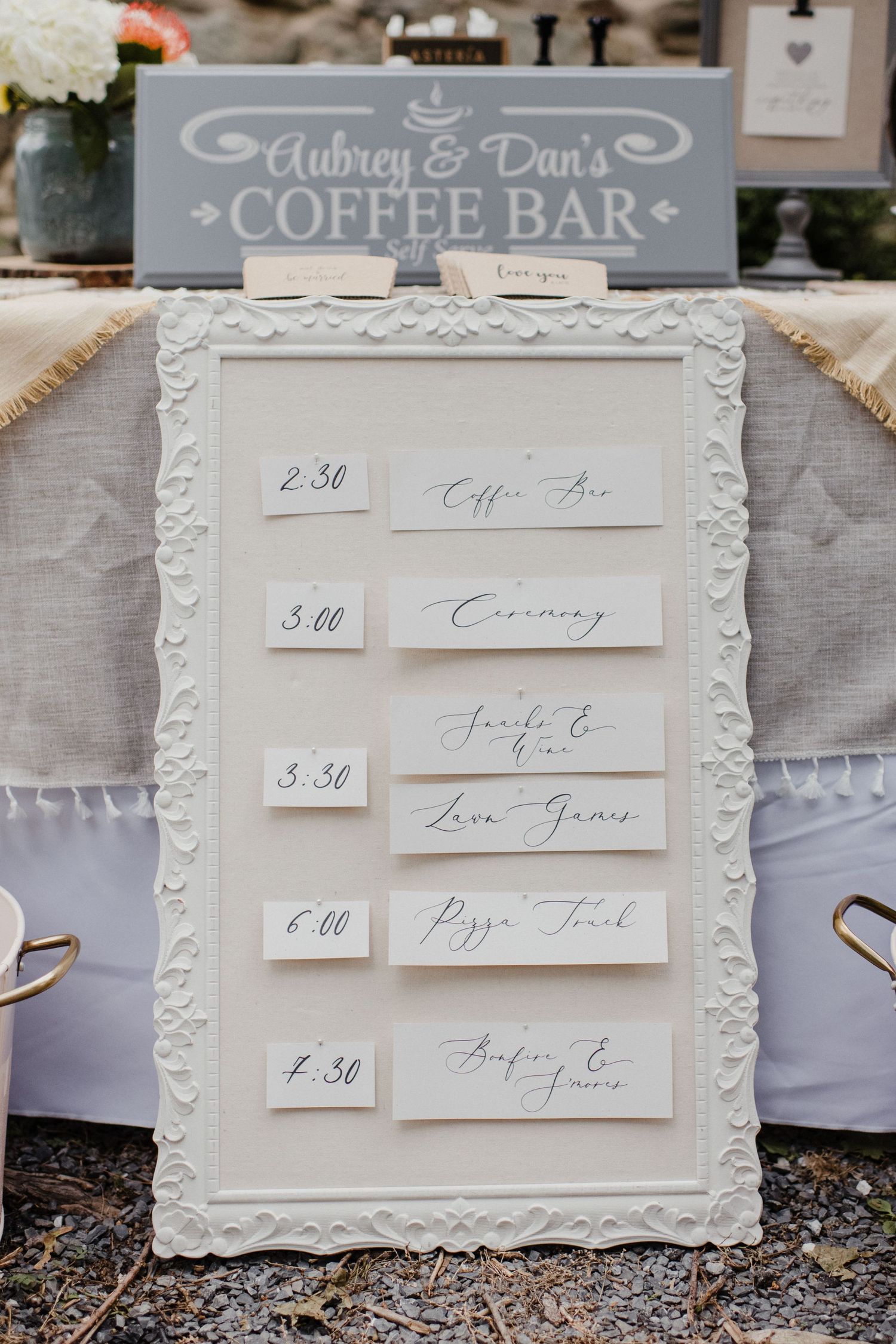 A wedding coffee bar schedule displayed in an ornate white frame with handwritten time slots.