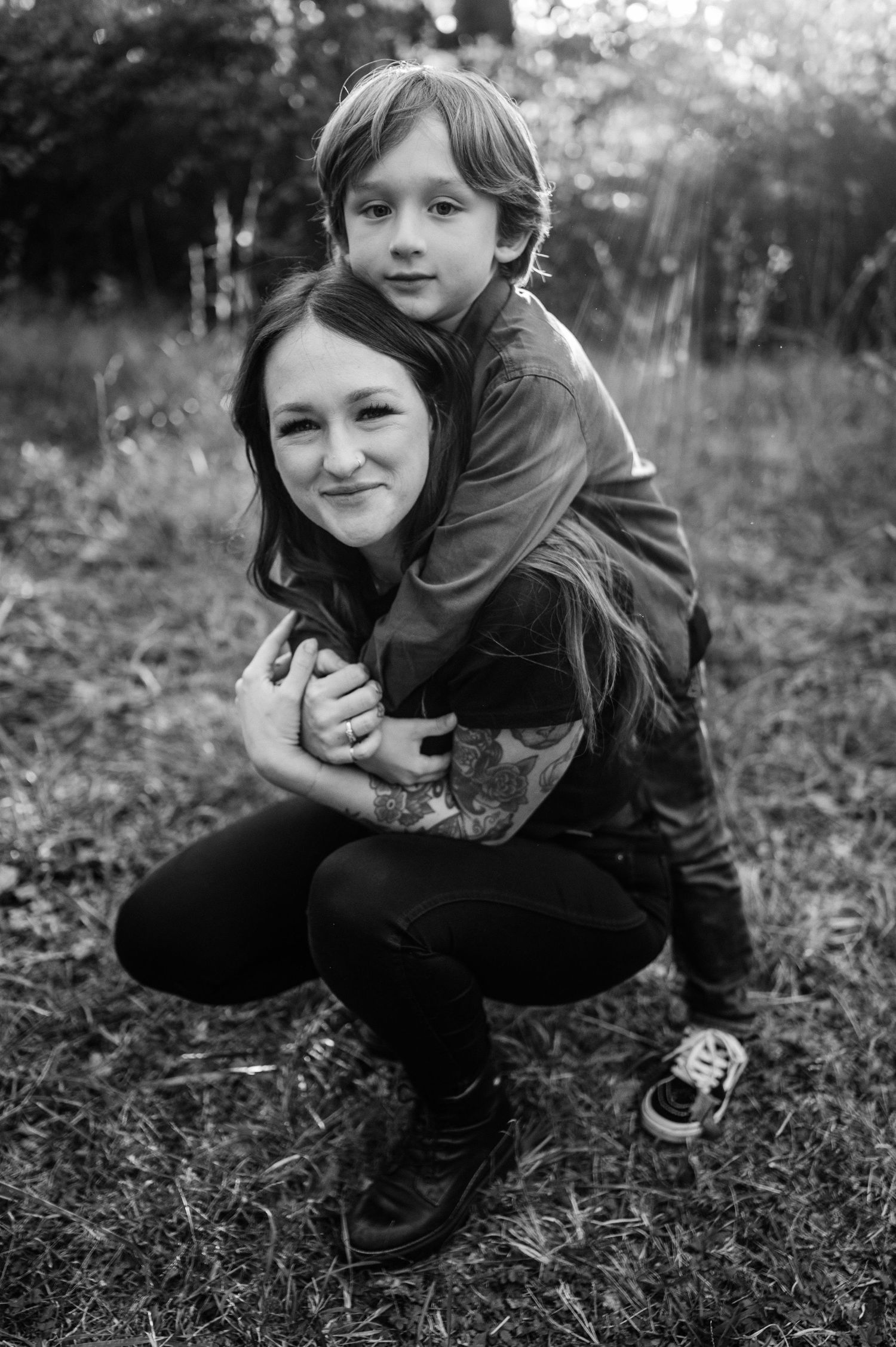 A joyful piggyback moment captured in black and white photography outdoors.