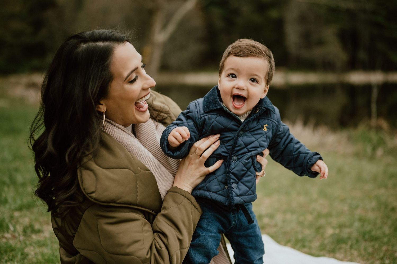 Joyful outdoor moment with child in navy jacket playing and laughing.