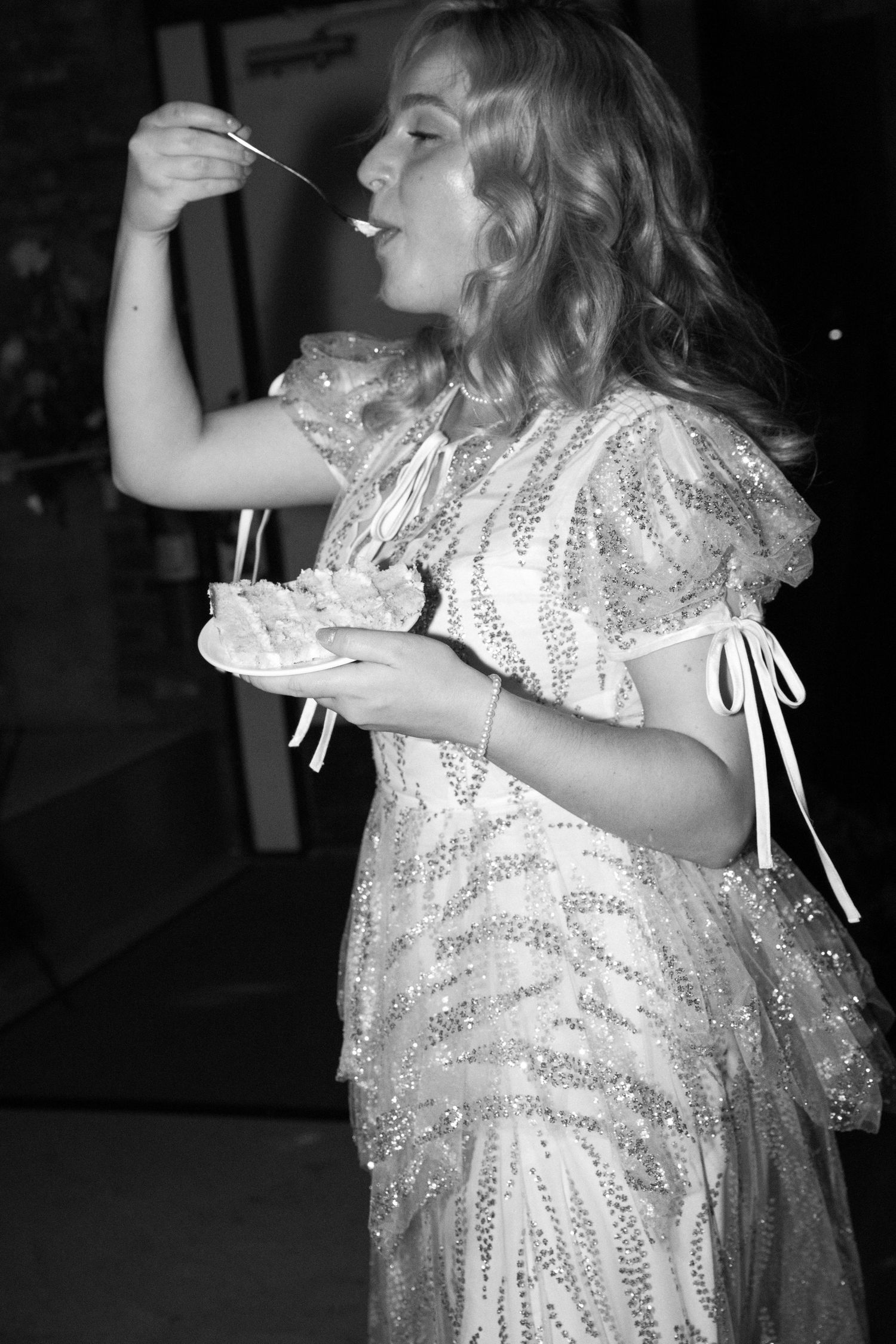Black and white photo of someone dancing in a sparkly dress with flowing movement.