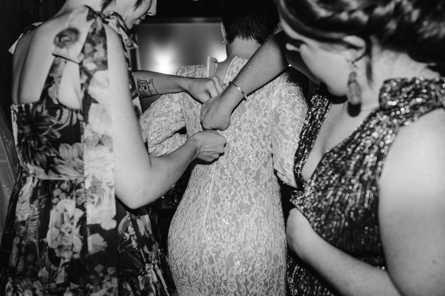 A close-up black and white shot of dress adjustments being made.