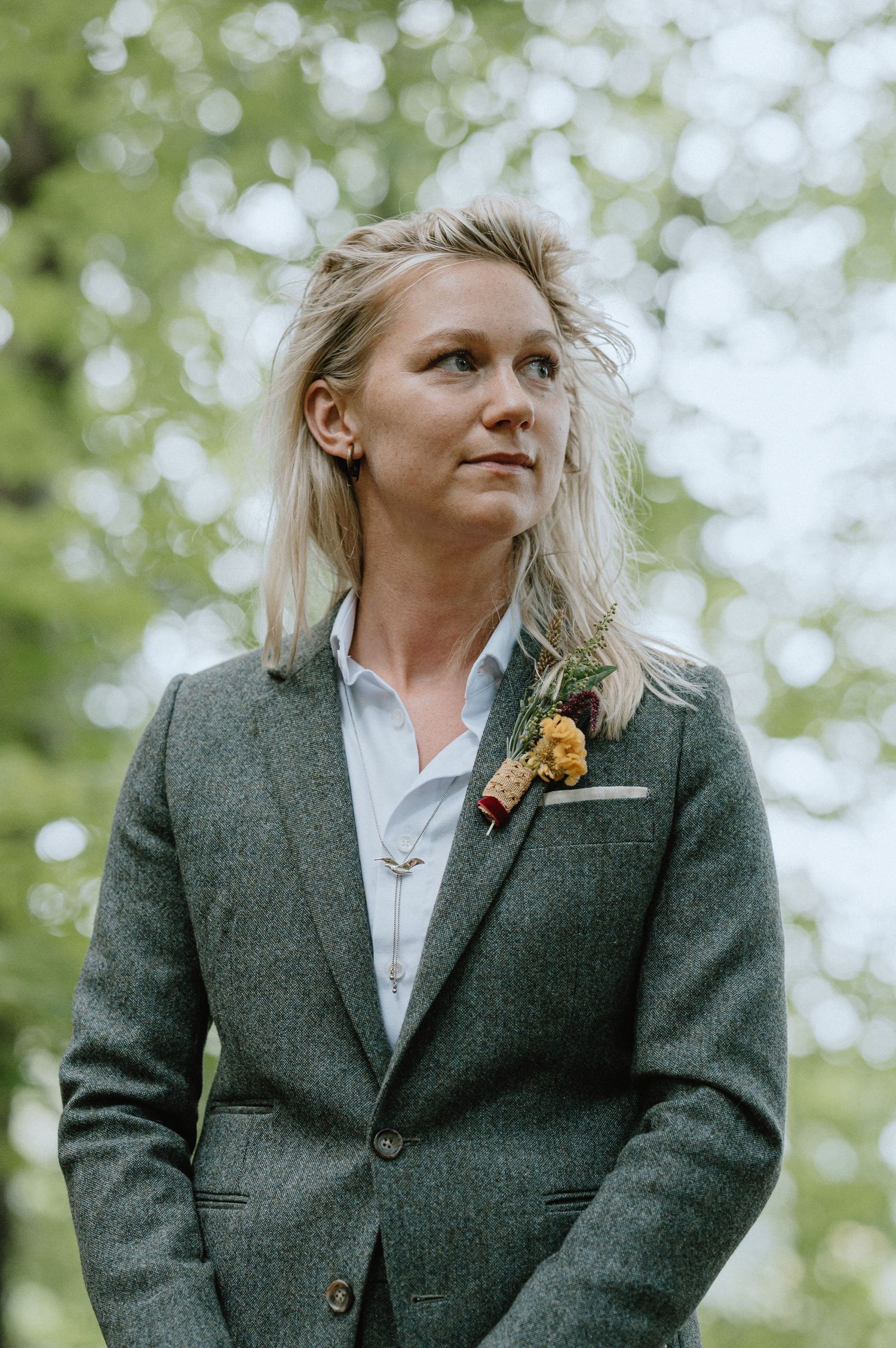 A wedding portrait showcasing formal attire against a soft, bokeh forest background.