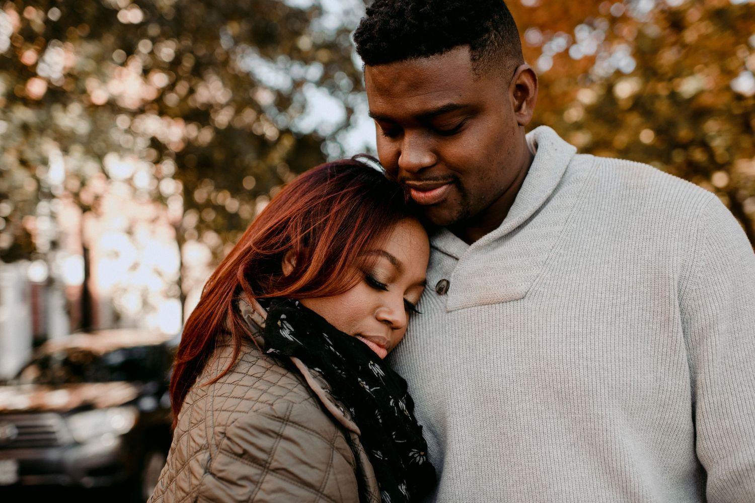 An intimate autumn portrait of a couple embracing outdoors.