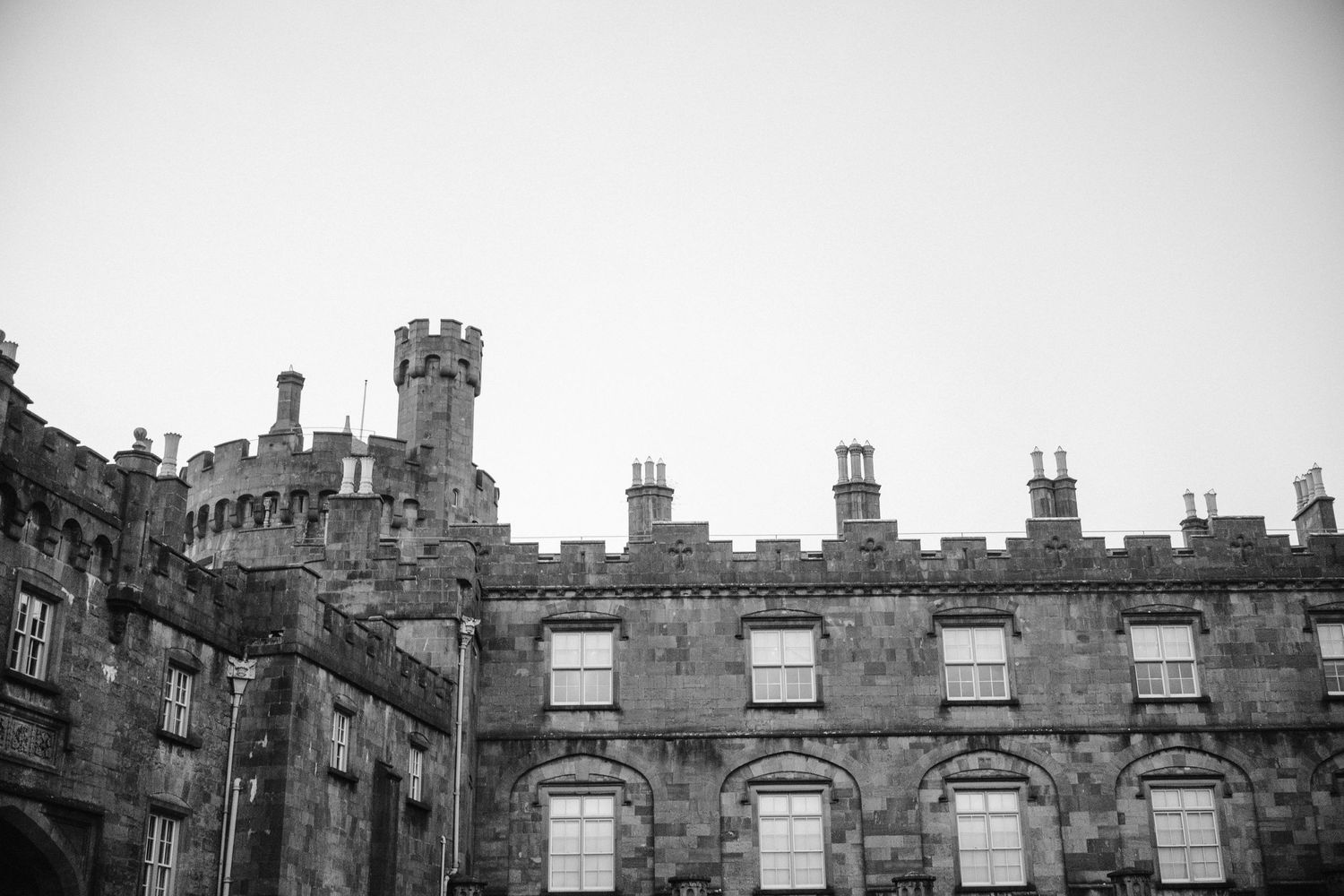 Black and white photograph of a Gothic castle with decorative windows and turrets.