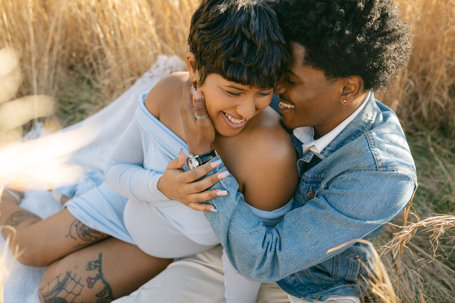 pregnant women laughs as husband gives hug