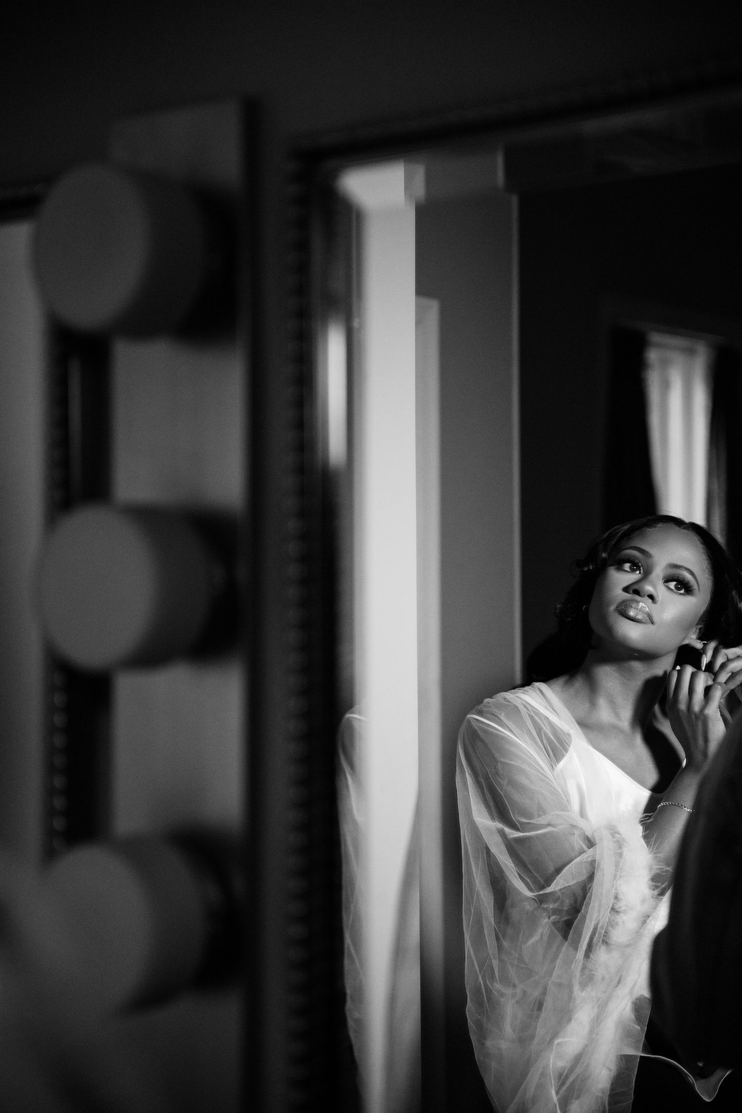 Artistic black and white portrait series showing ethereal poses in white fabric against dark background.