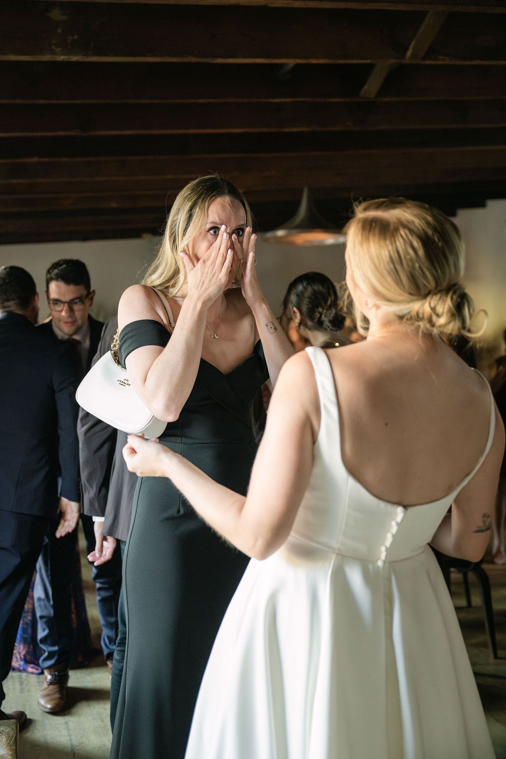 Emotional moment between guests at an indoor celebration.