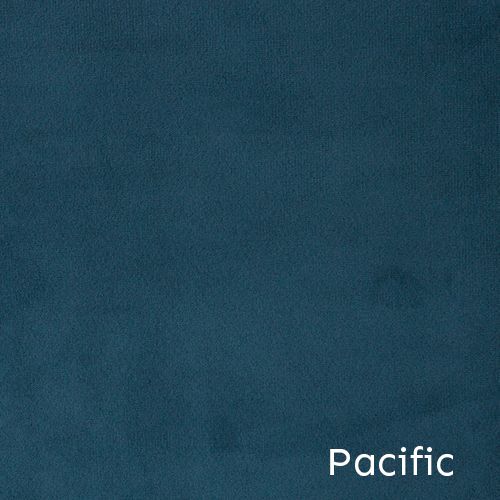 Aerial view of Pacific coastline with turquoise waters and rugged cliffs under a deep blue-tinted sky.