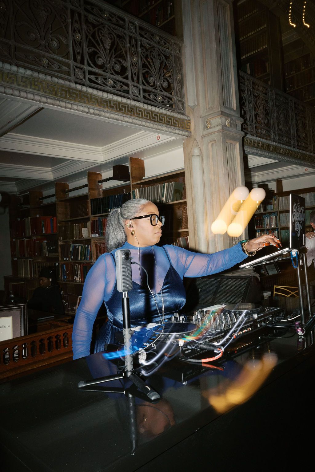 DJ equipment and lighting setup in a dark venue with ornate architectural details.
