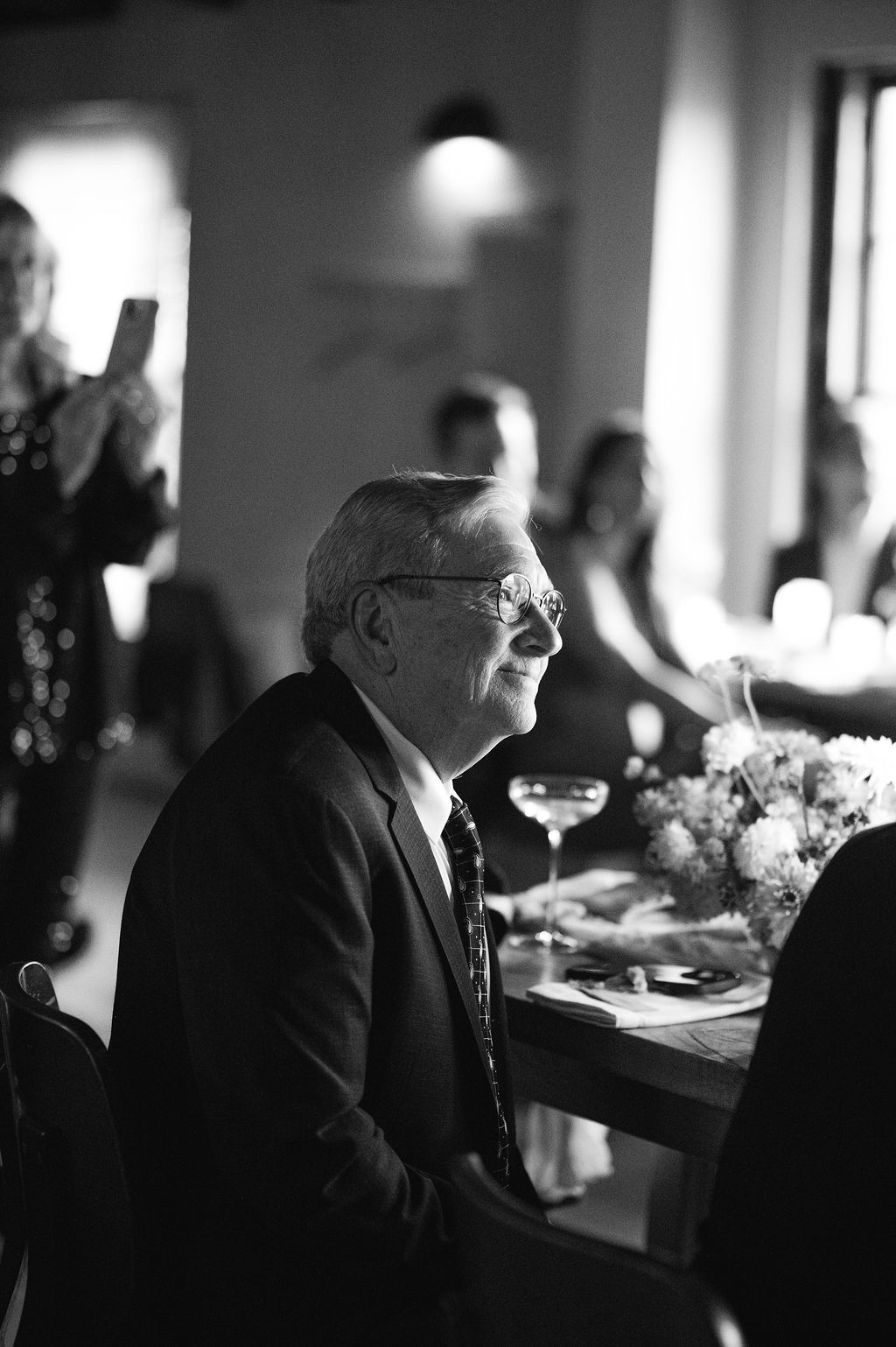 Elegant black and white portrait of guests at a formal dining event.
