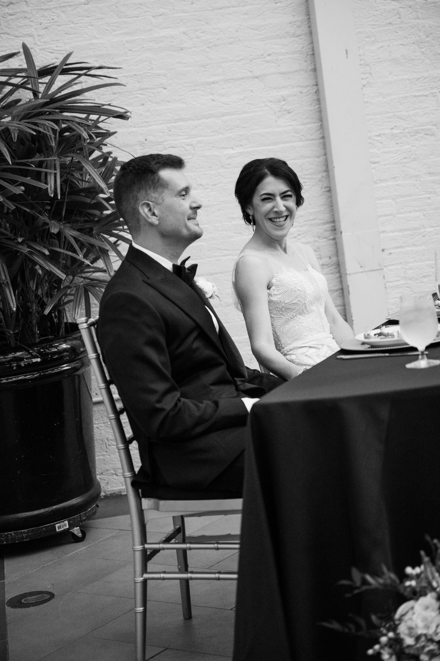 A black and white portrait of a couple seated at their wedding reception table at a baltimore engineers club wedding