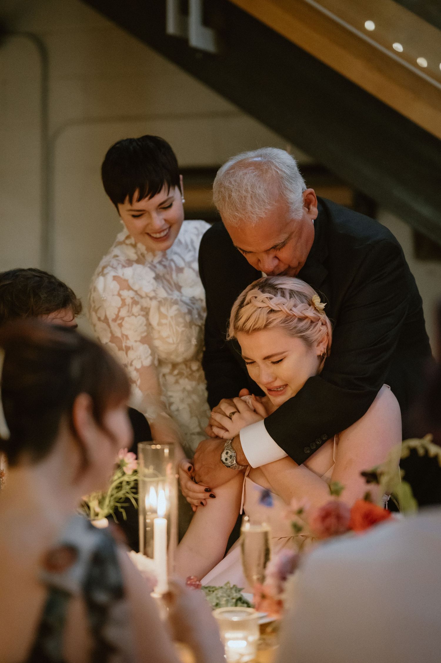 Emotional moment captured during wedding reception dinner with candlelit ambiance.