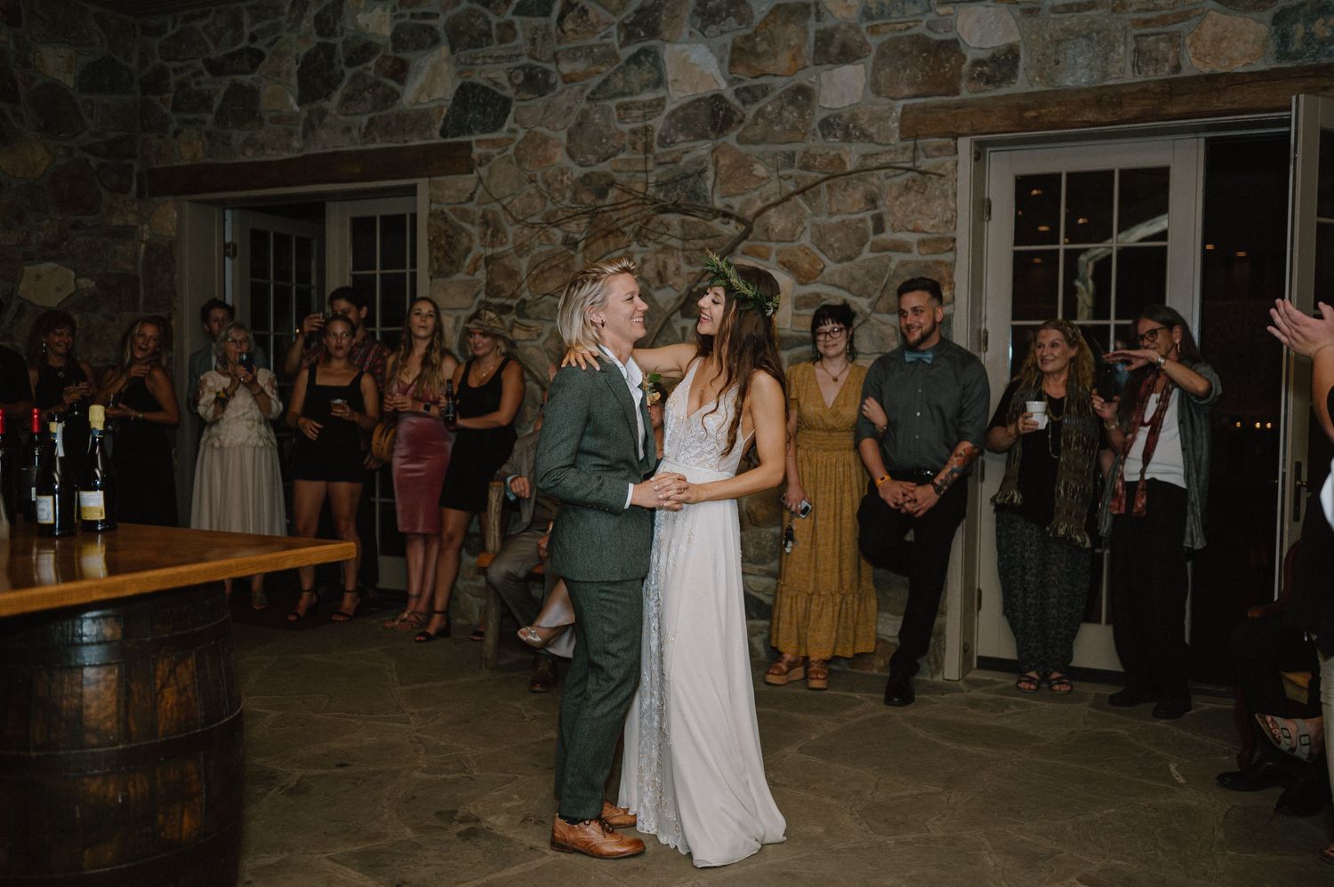 A romantic first dance moment in a rustic stone-walled reception venue.