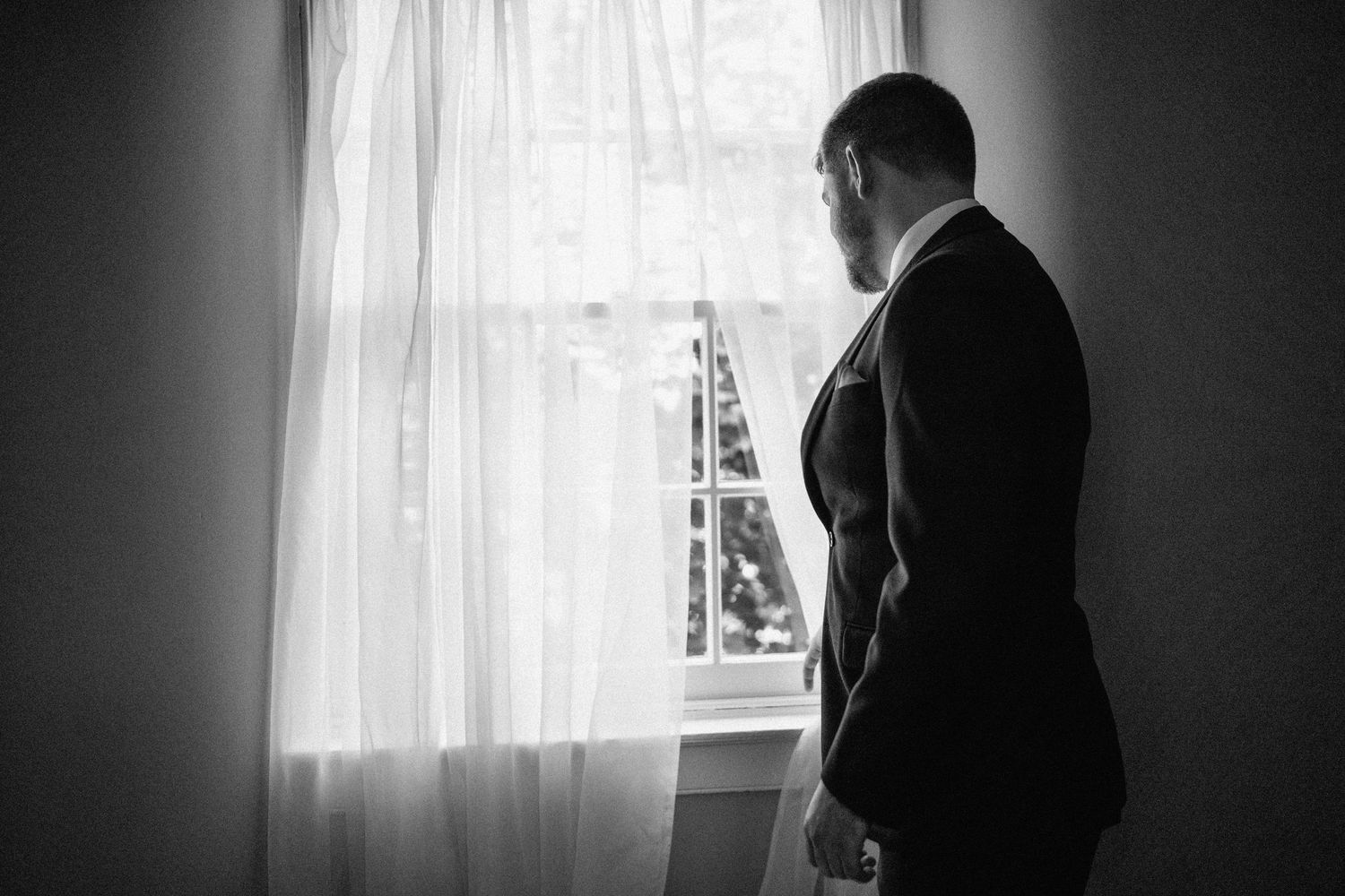 groom looks out window