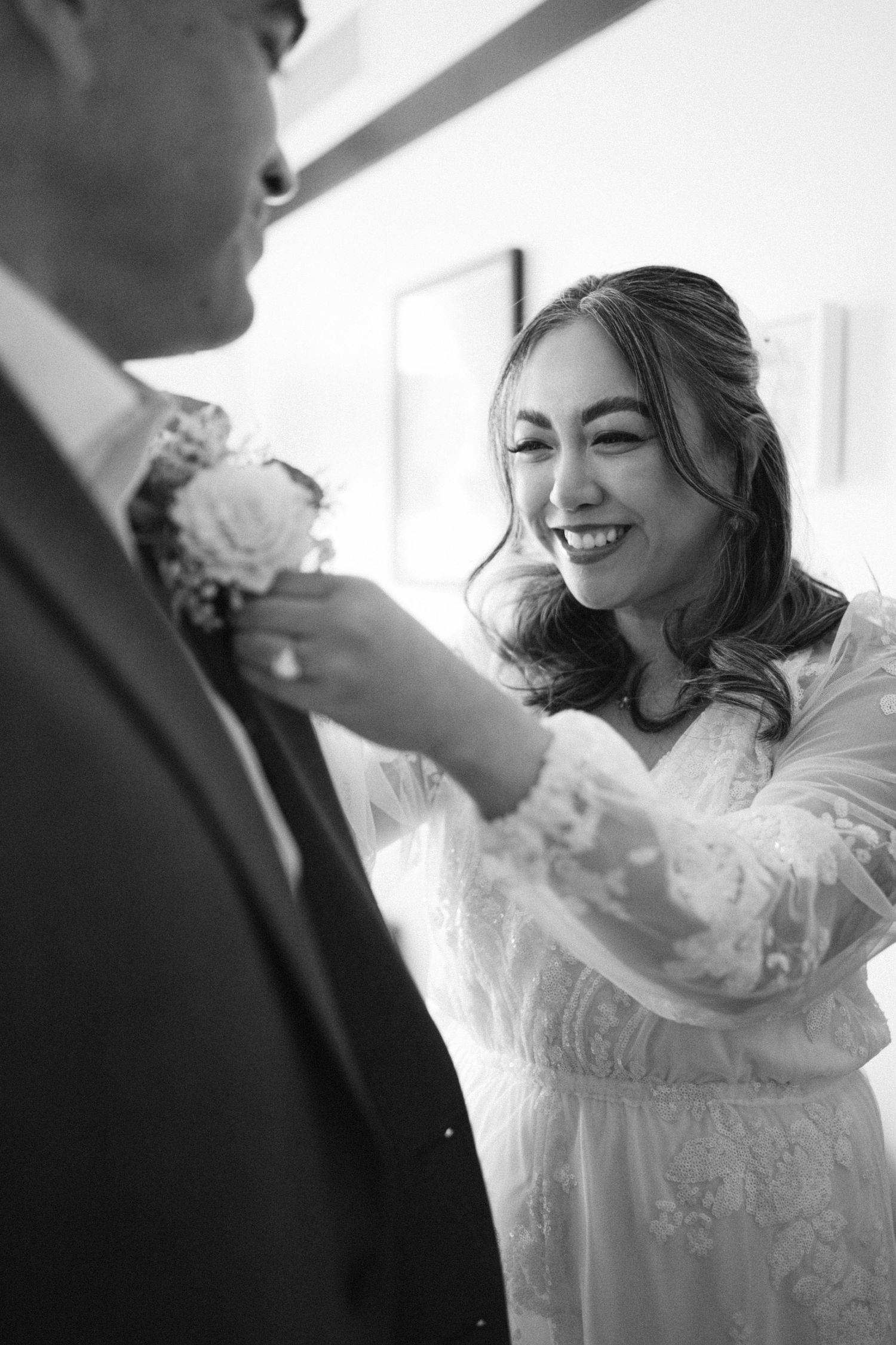 A black and white candid moment as a couple prepares for their wedding ceremony.