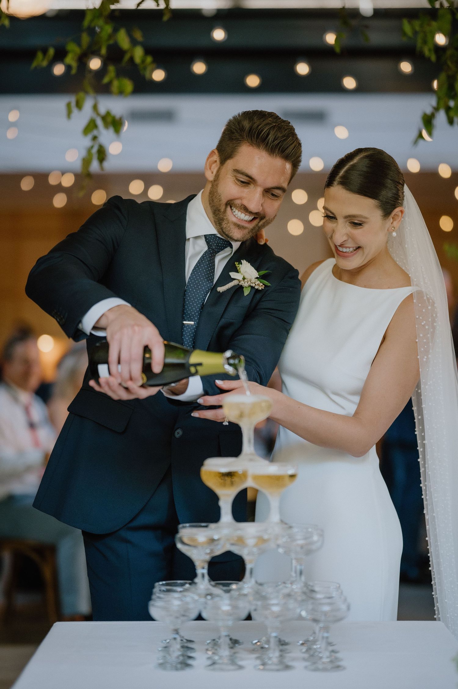 bride and groom fill champagne tower at woodberry kitchen wedding