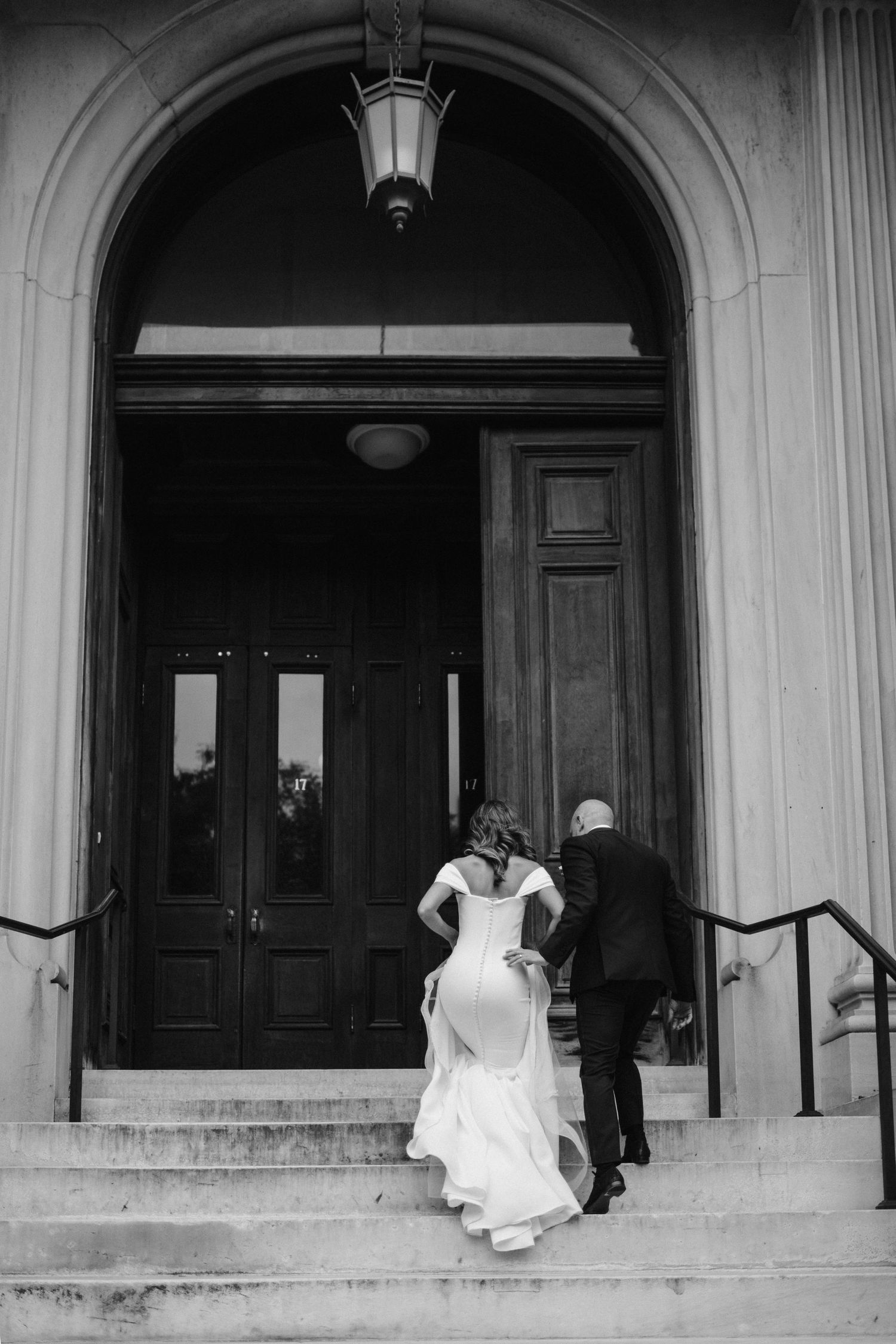 bride and groom walk up the steps to the George peabody library