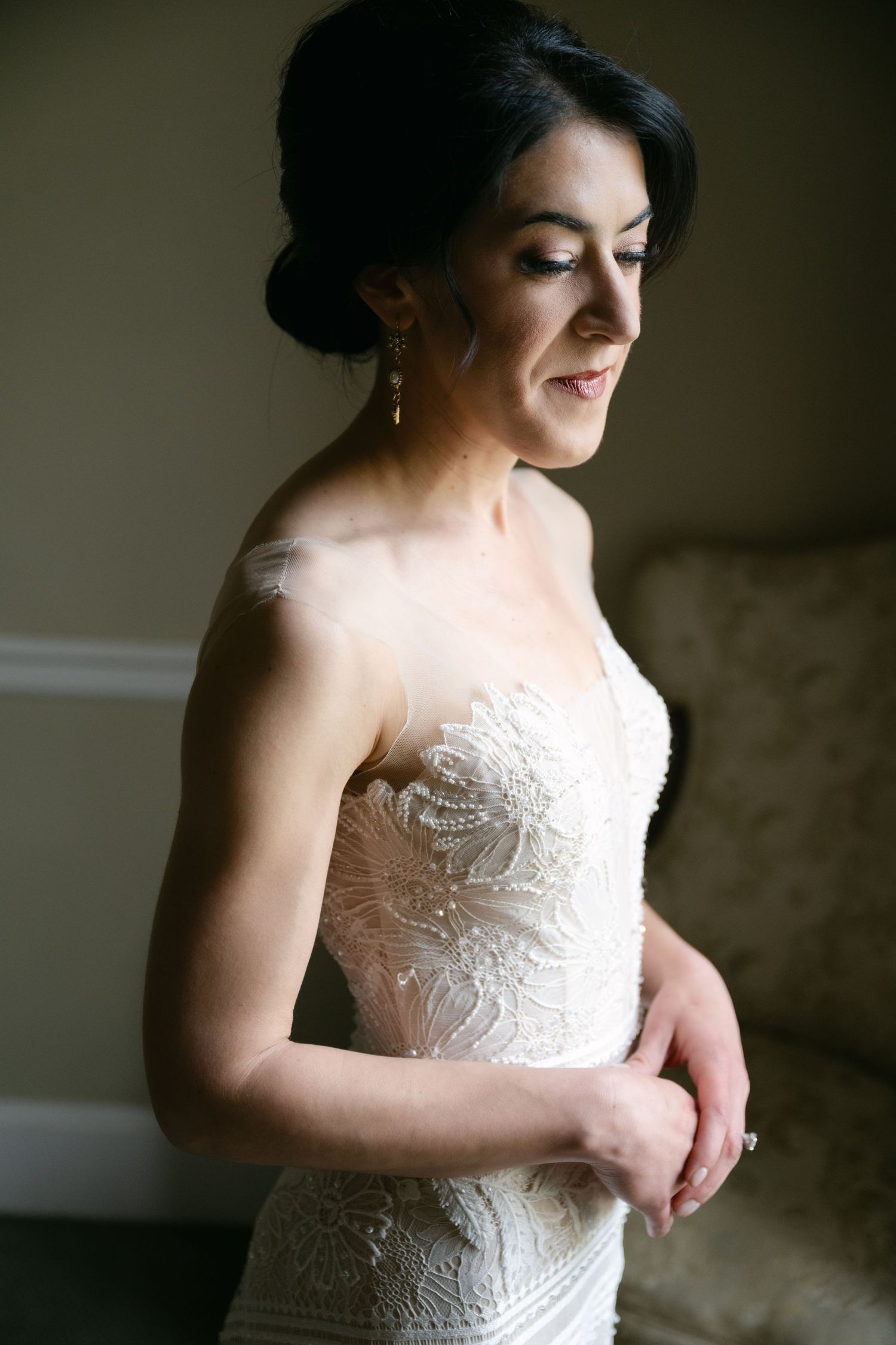 A close-up detail shot of an intricate lace wedding dress with sweetheart neckline.