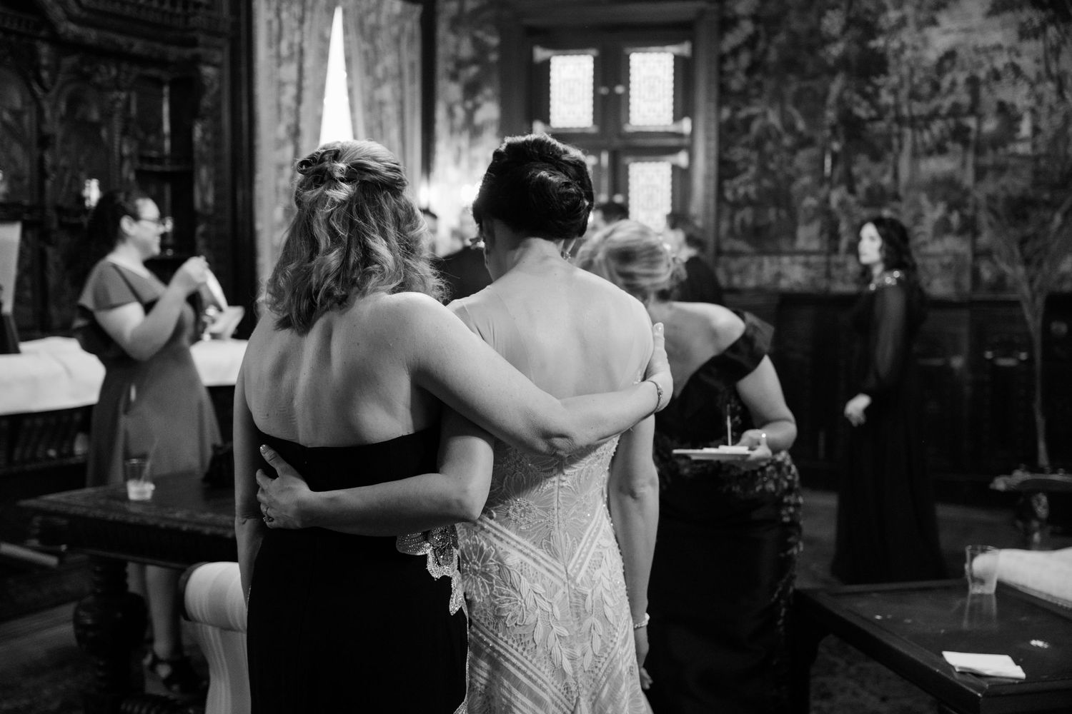 Black and white candid photo of wedding preparations in a rustic venue.