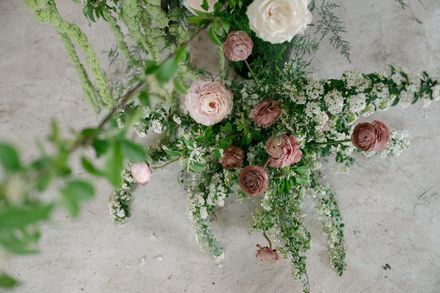 Delicate pink and white roses with greenery arranged in an elegant floral display.