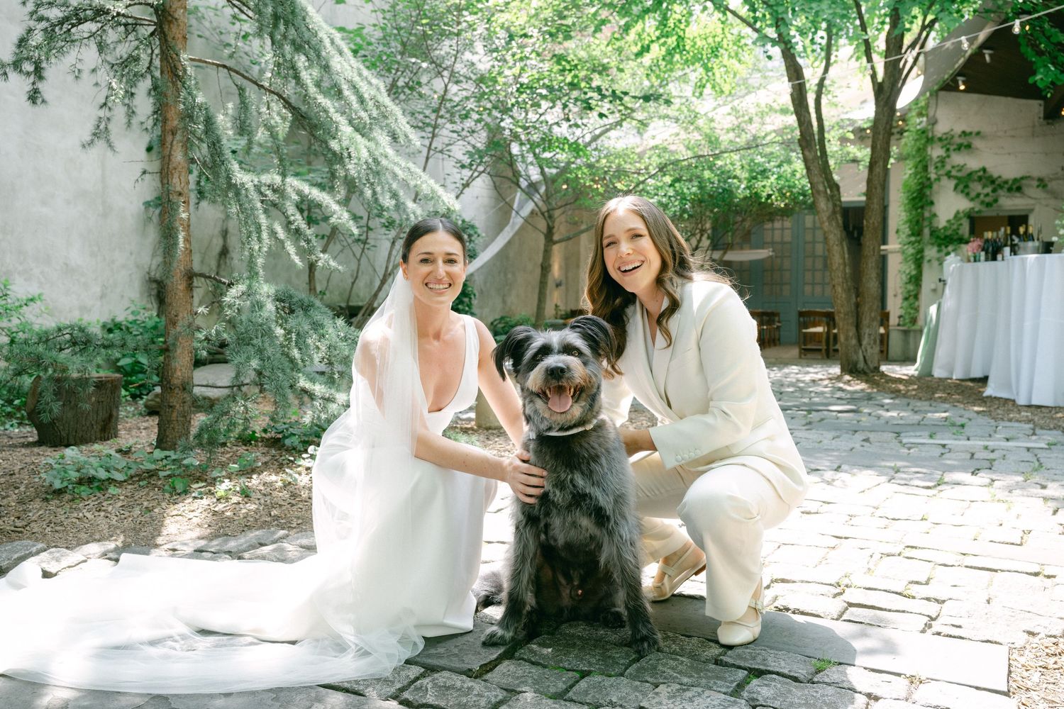 Wedding couple enjoying a quiet moment in a garden setting with their dog.