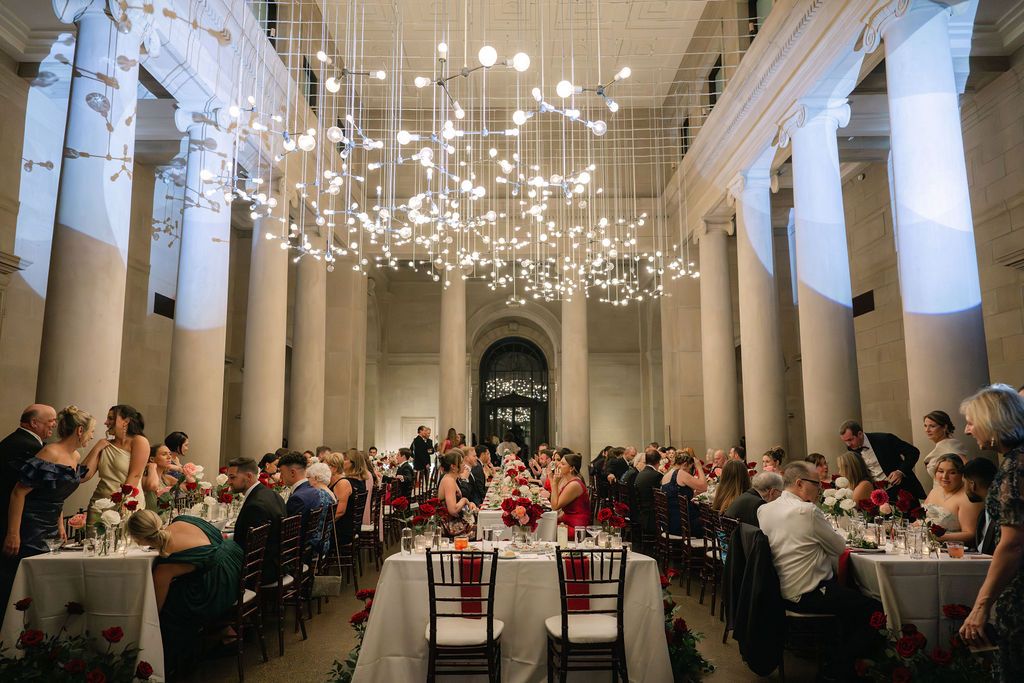 Elegant banquet hall with white columns and crystal chandeliers set up for formal dining event.