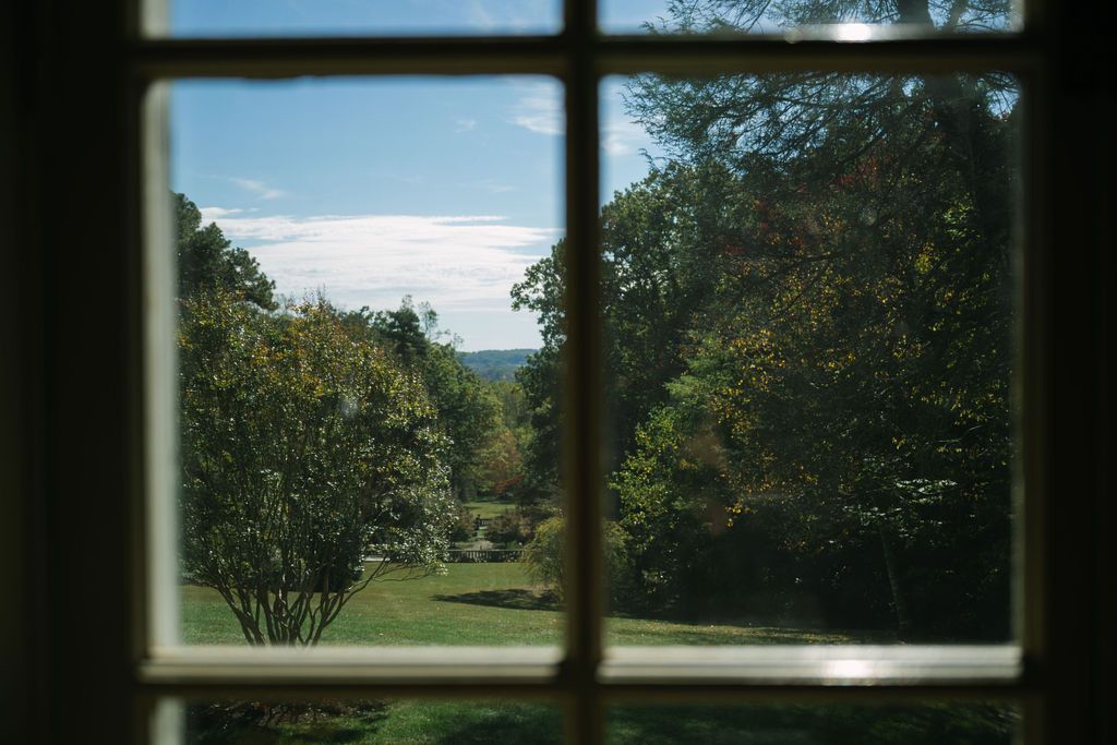 View through a window pane of a scenic green landscape with rolling hills and trees at Strong Mansion on Sugarloaf Mountain
