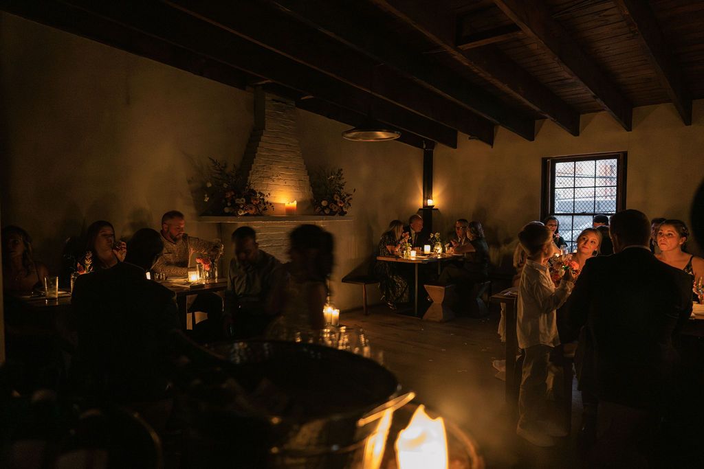 Dimly lit reception venue with exposed wooden beams and ambient lighting Fadensonnon in Baltimore