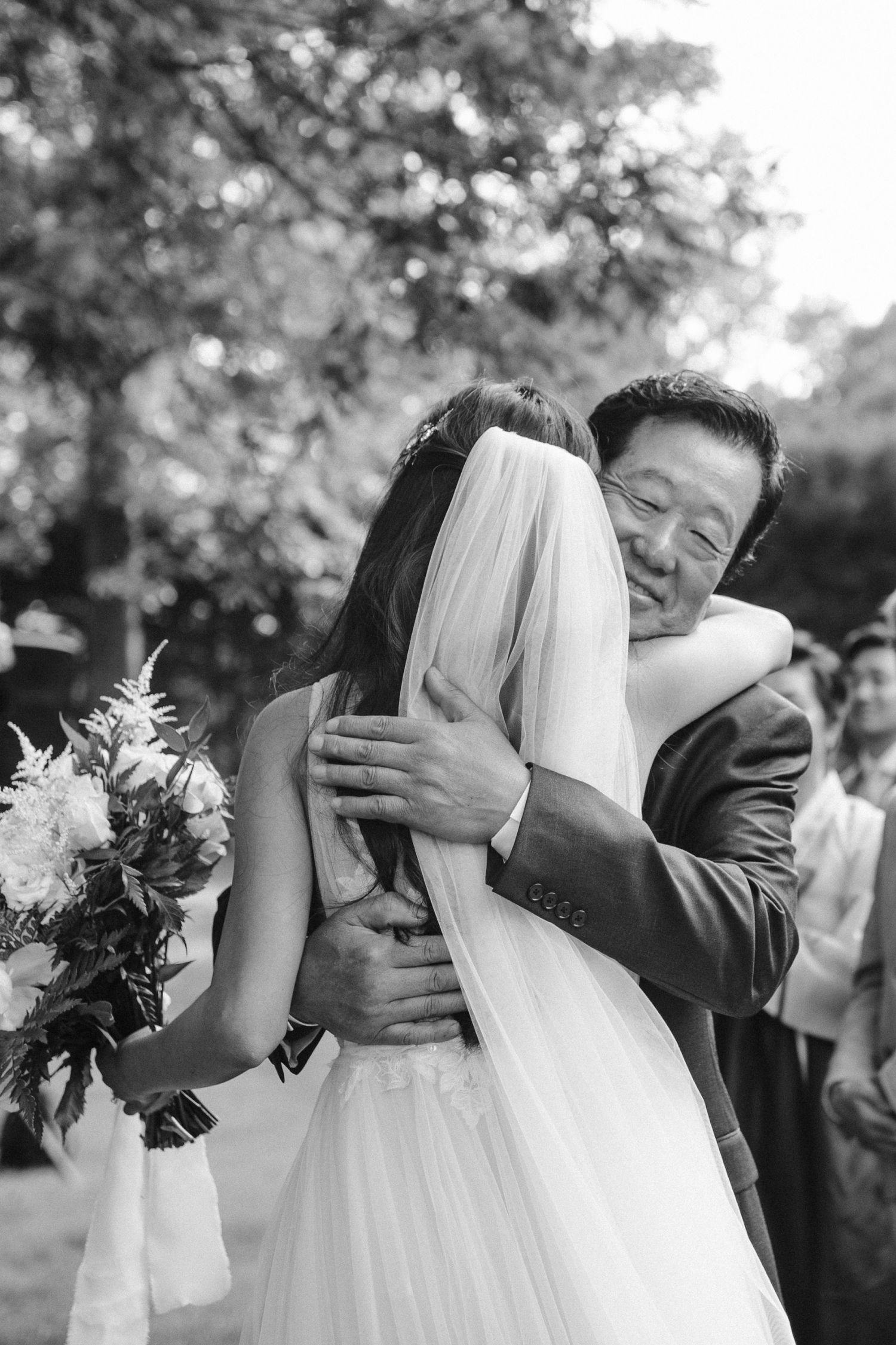 Emotional wedding moment captured in black and white photography outdoors.