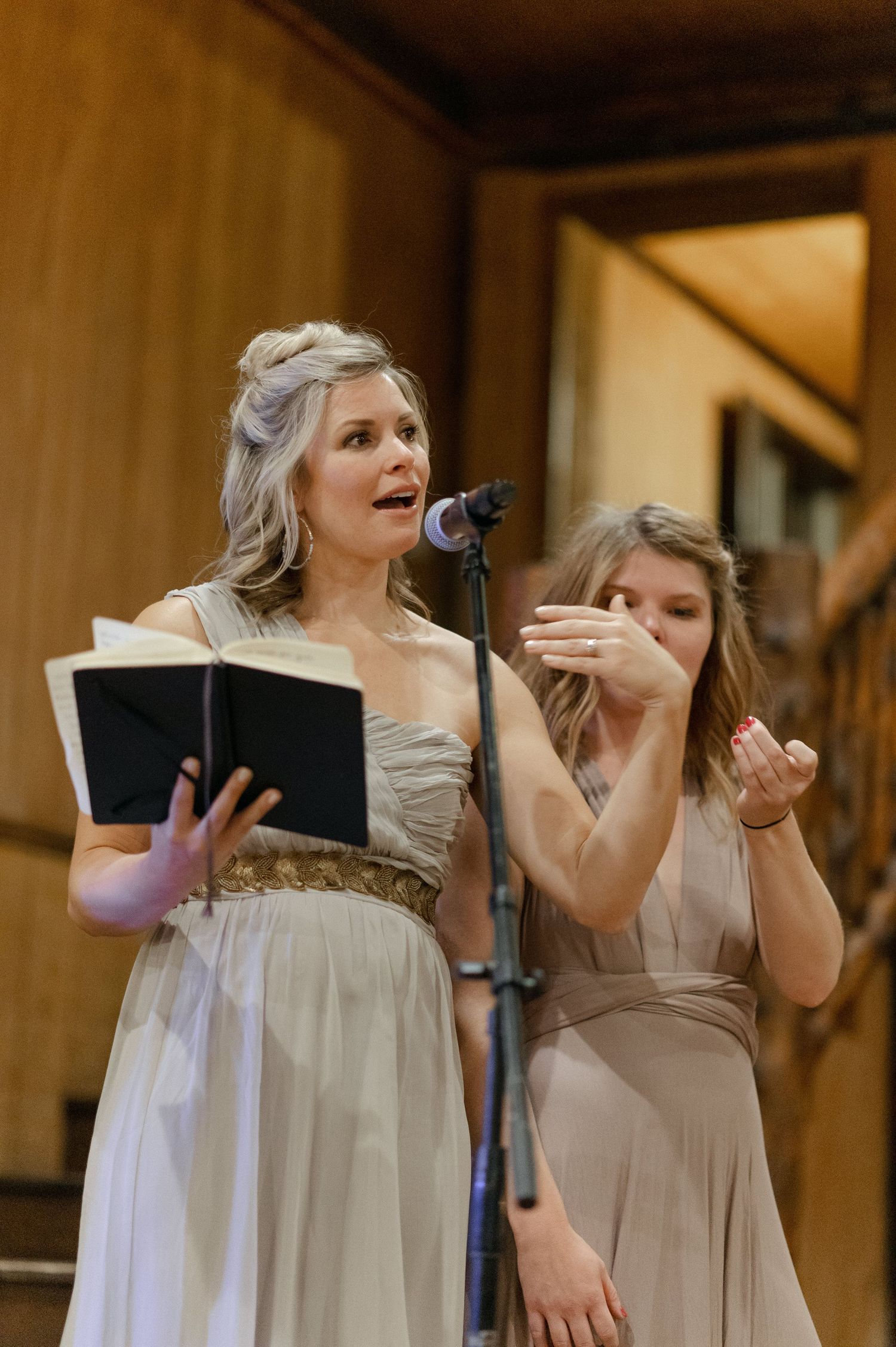Two people performing during a wedding reception in a rustic wooden venue.