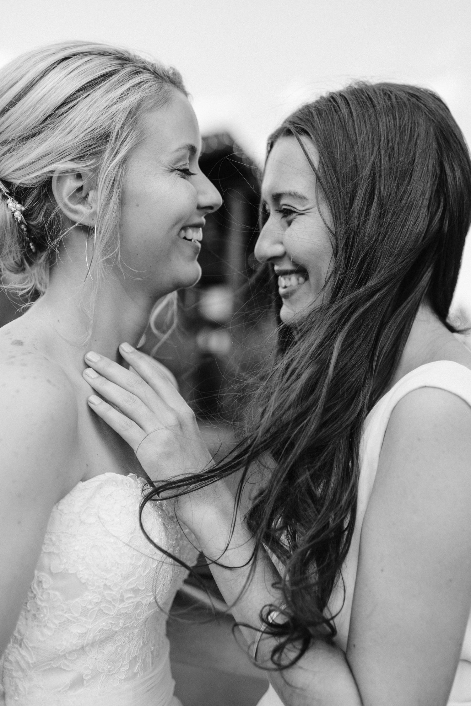 An intimate black and white moment shared between two people in wedding attire.