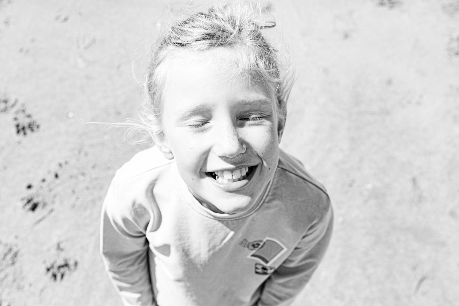 Close up black and white portrait on sandy beach. Kindportret.