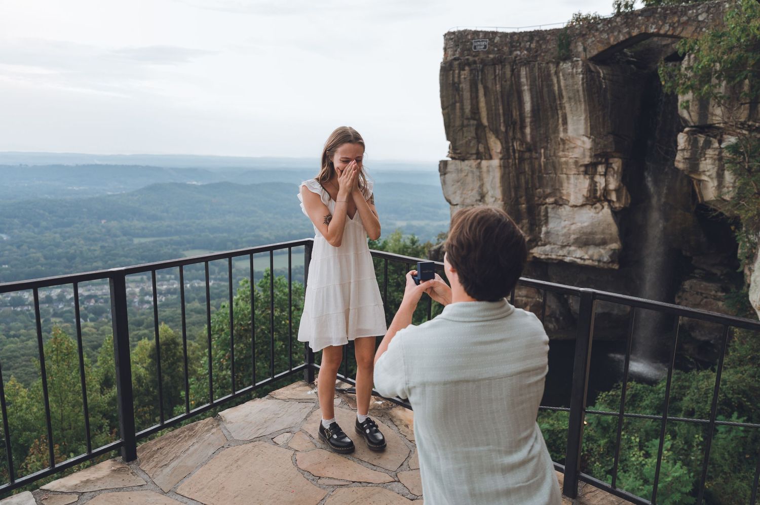 A bride and groom share a romantic moment at Lookout Mountain overlooking a scenic valley vista.