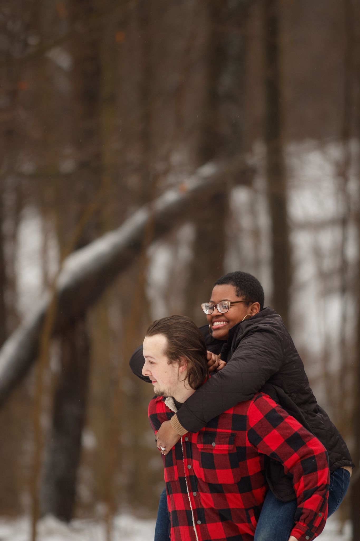 An engaged couple having a fun time in the snow