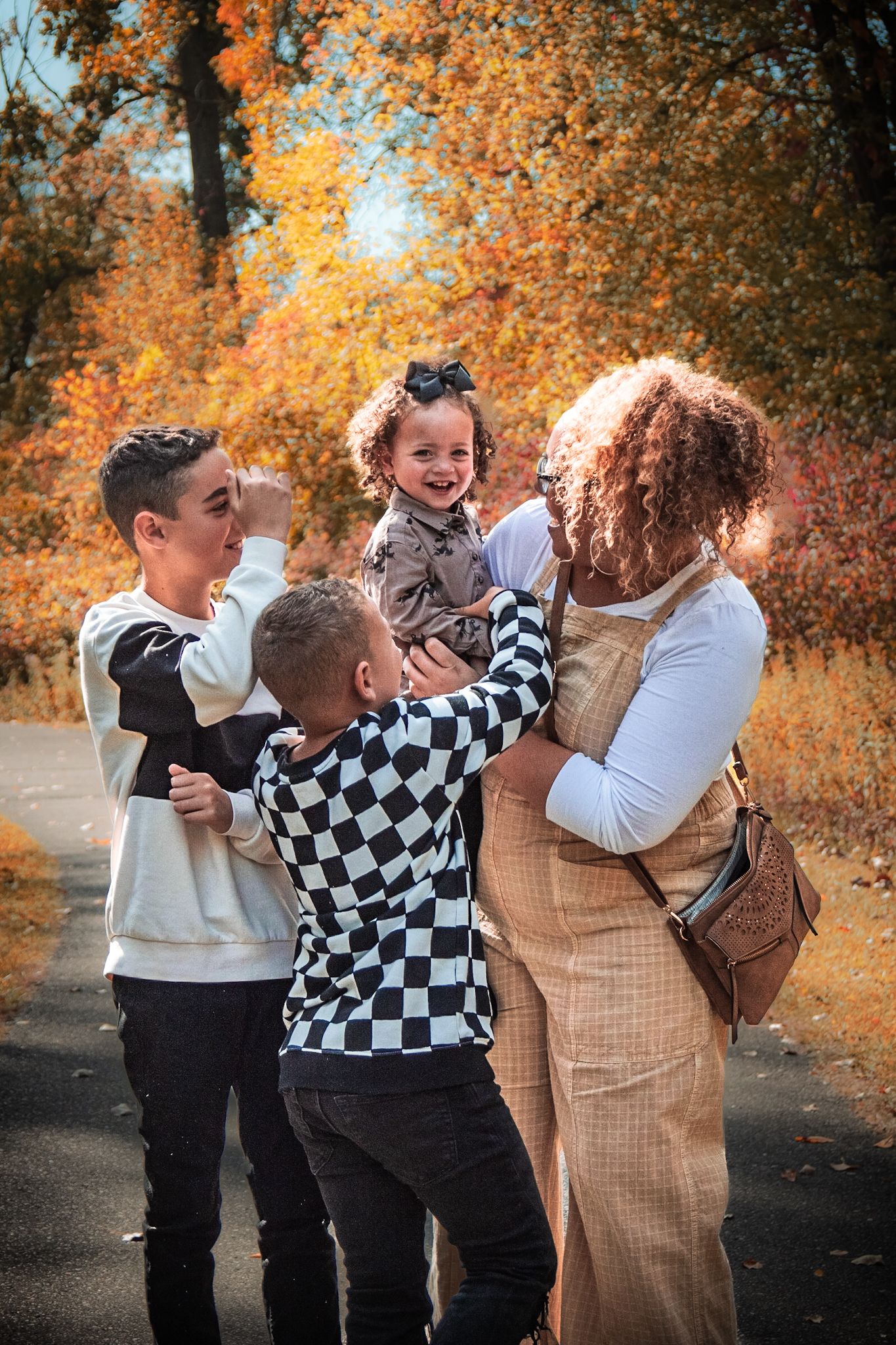 People sharing joyful moments together against vibrant orange autumn foliage background.