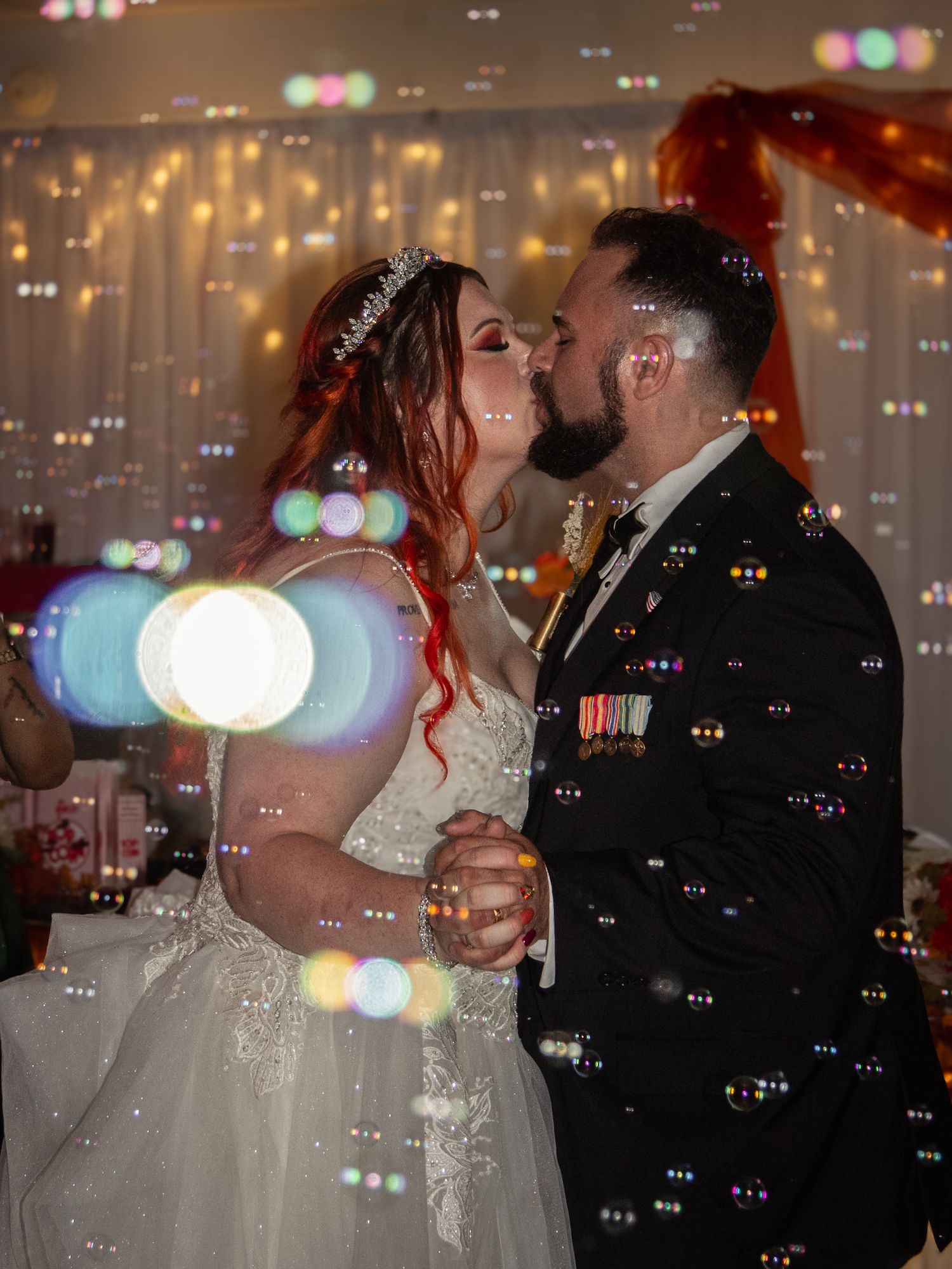 Newlyweds share their first dance surrounded by romantic bokeh lights and bubbles at their wedding reception.