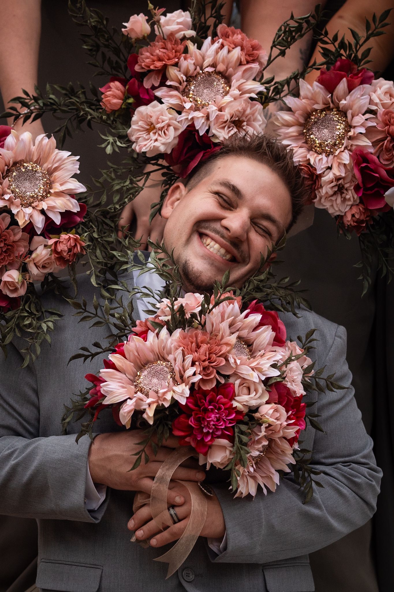 A joyful portrait with pink and red flowers framing the composition.