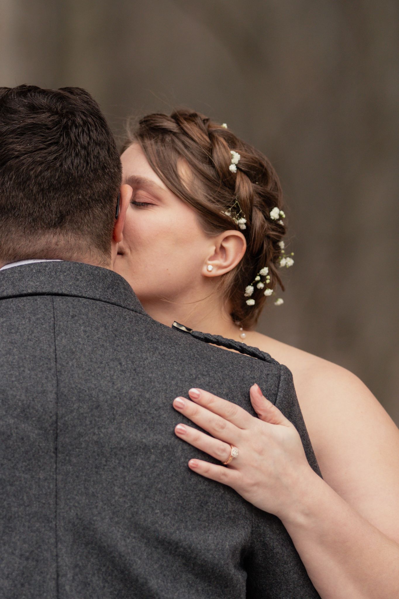 A tender romantic moment captured between newlyweds with delicate flowers woven into the bride's hair.