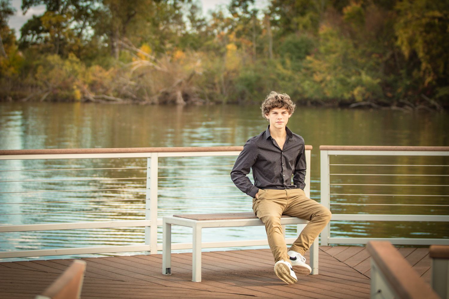 A sunny lakeside setting with a wooden dock stretching over calm waters.