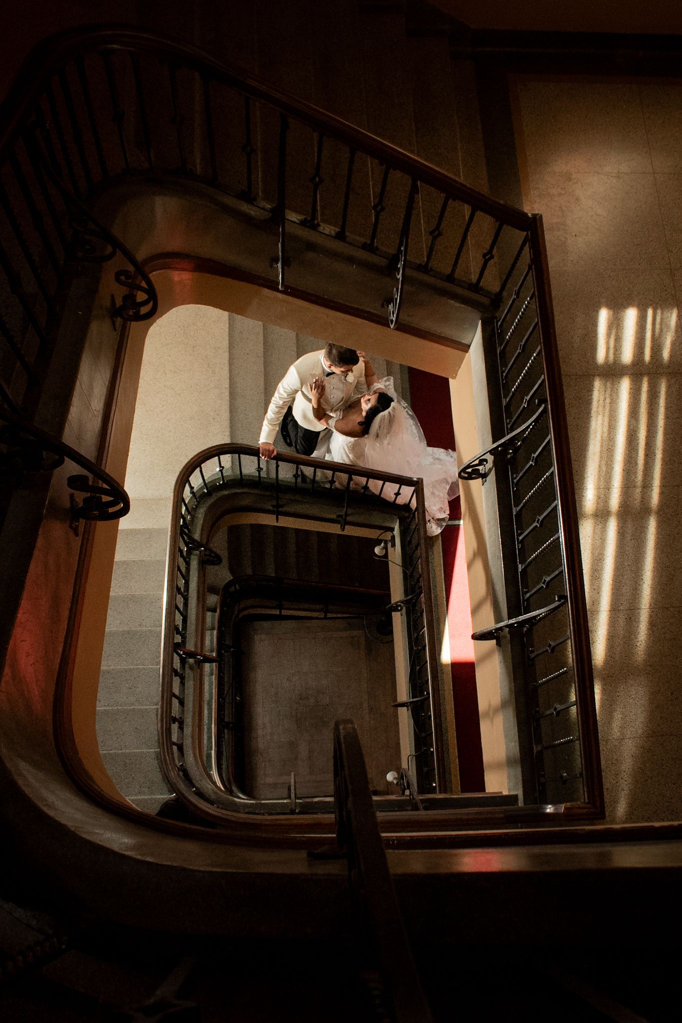 Artistic spiral staircase photo with dramatic shadows and architectural details.