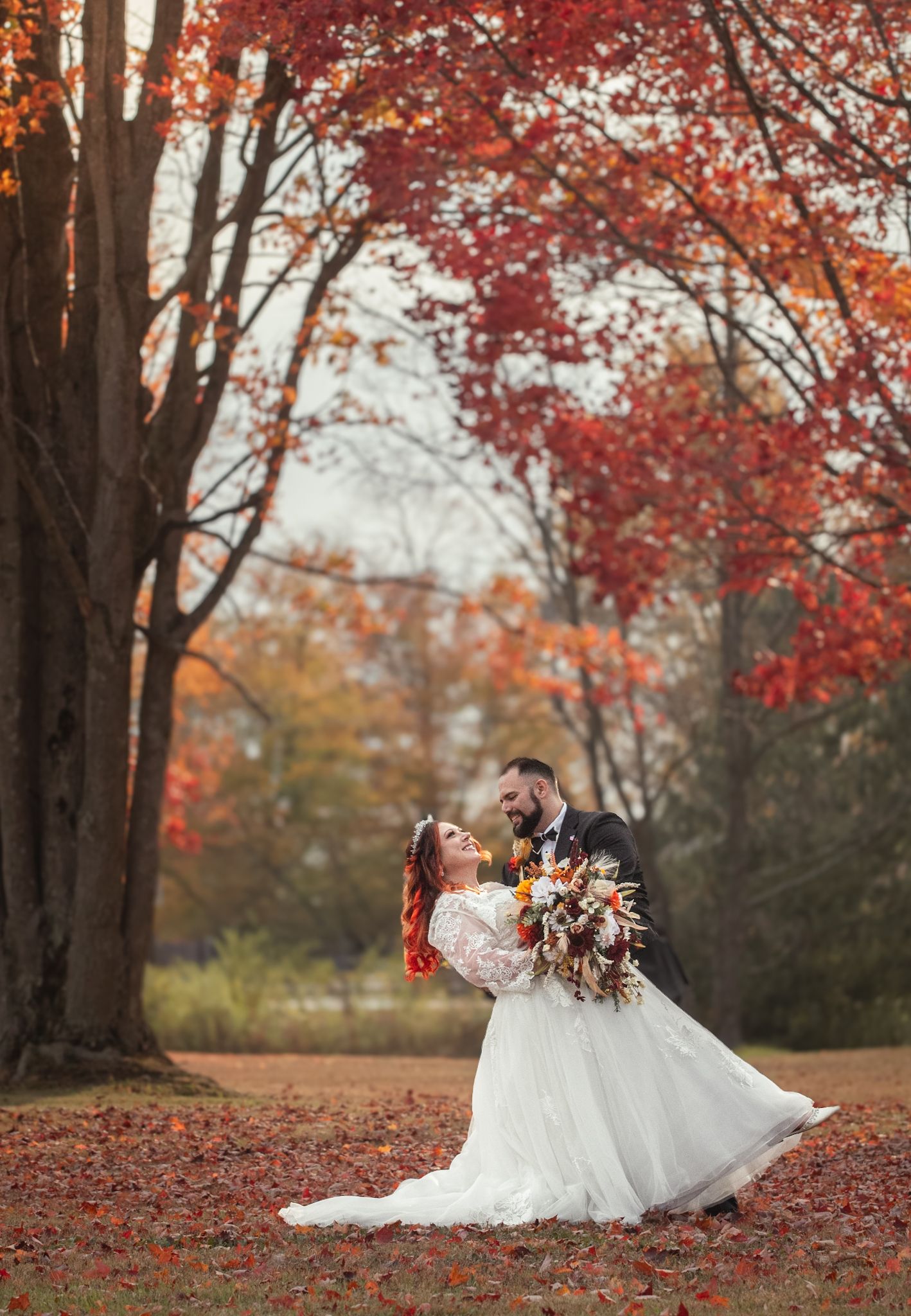White wedding dress twirls gracefully among vibrant red autumn leaves in a romantic outdoor photo sequence.