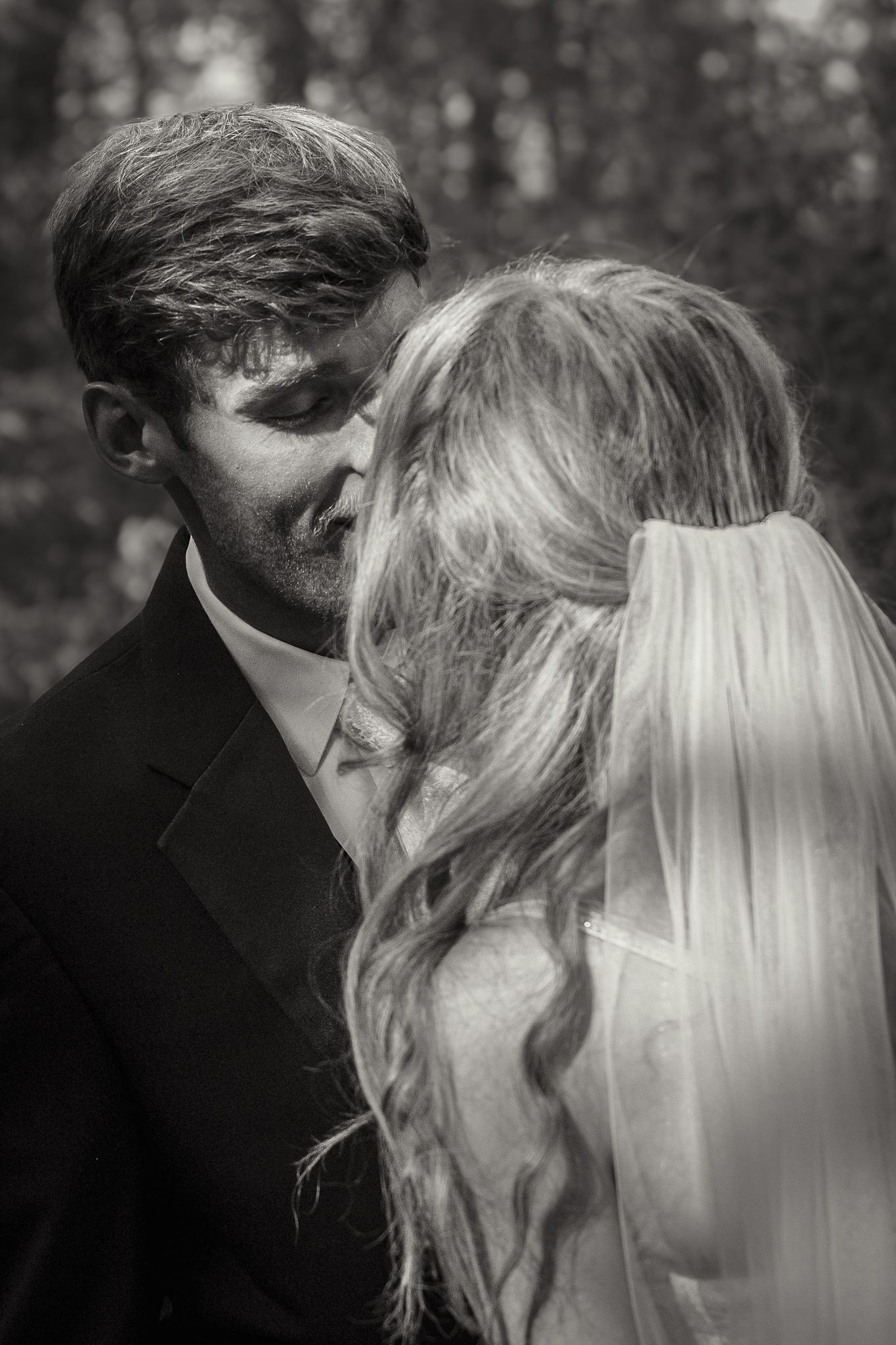 A black and white romantic kiss captured in an intimate close-up shot with soft lighting.