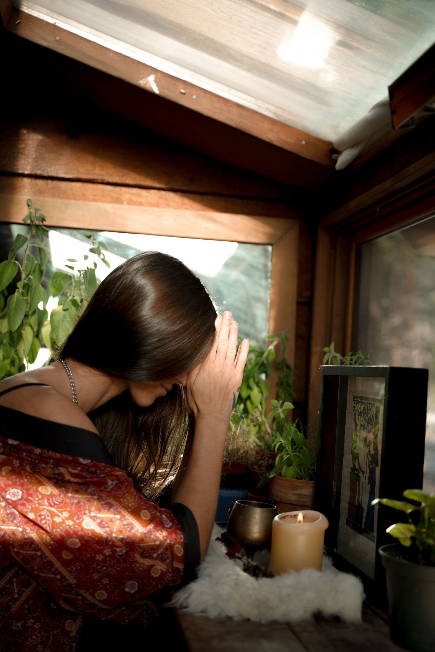 Interior scene with candles and plants by window creating cozy atmosphere.