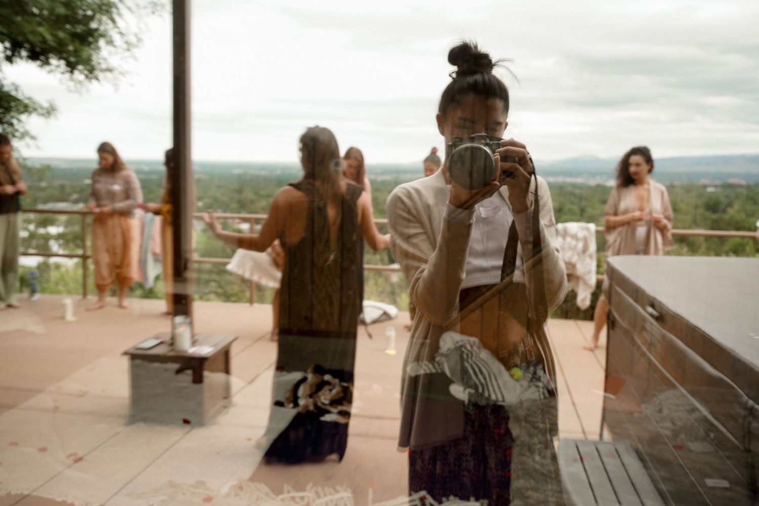 People standing on an outdoor deck overlooking a scenic landscape.