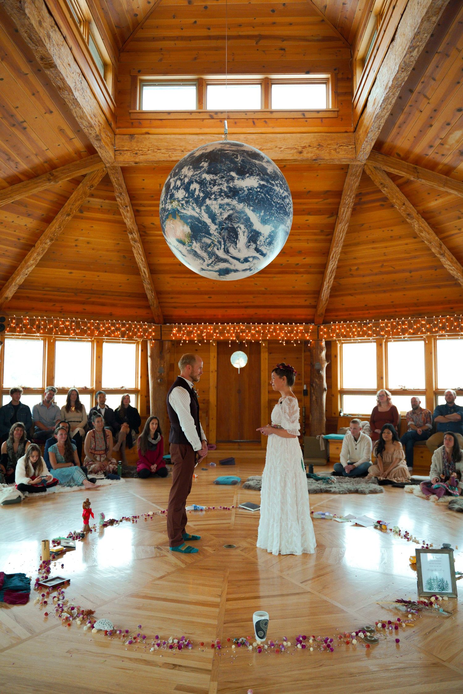 Panoramic view of a wooden yoga studio space with exposed beams and natural light streaming through skylights.