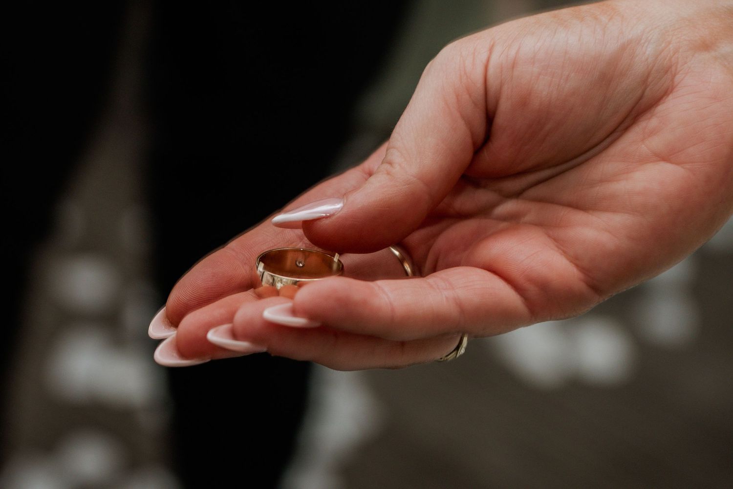 Close-up of wedding rings resting in an open hand, captured with a softly blurred background.