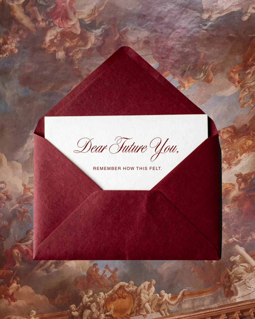 A deep red velvet envelope holding a white card reading Dear Future You, Remember How This Felt, on baroque background.