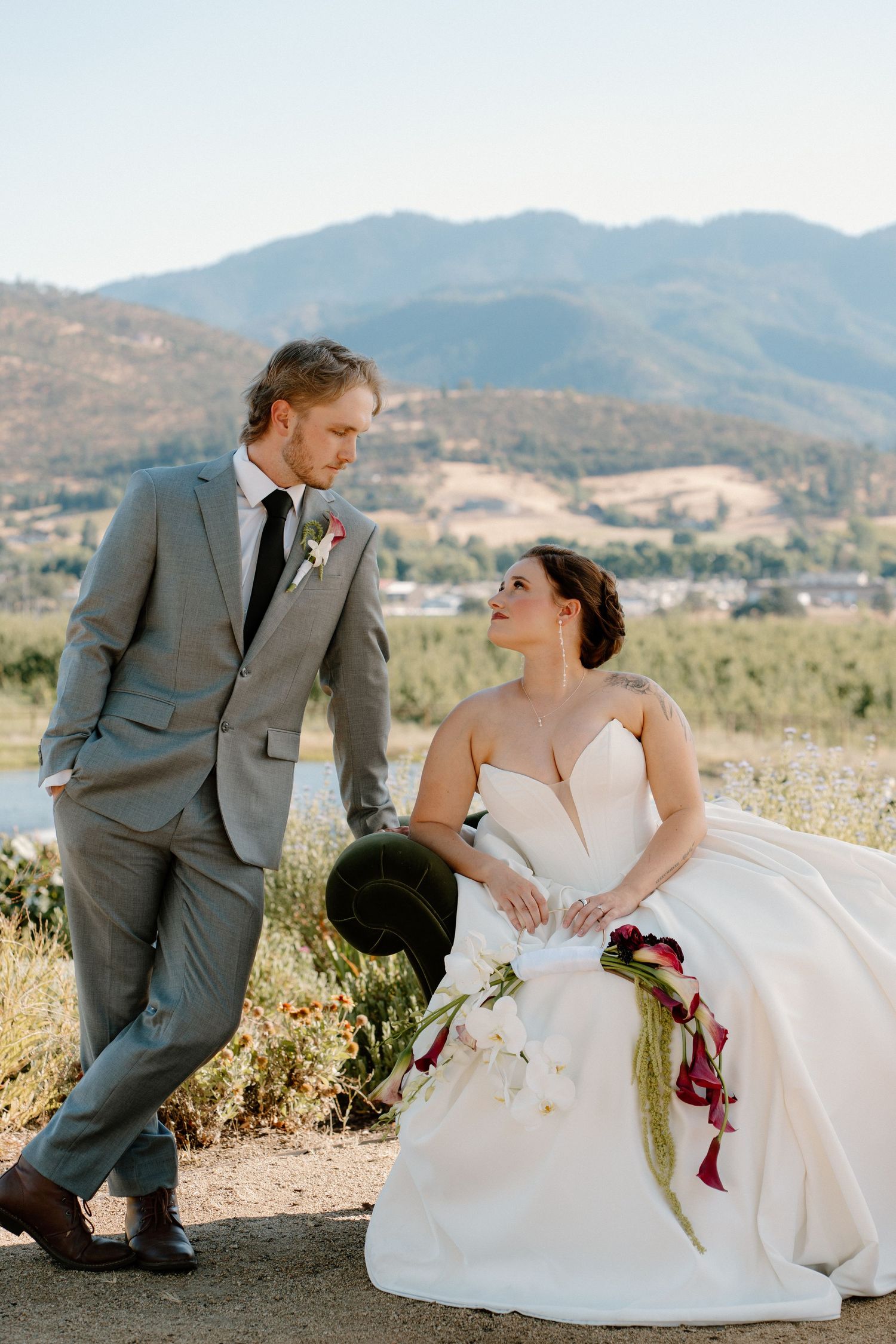 Bride and groom share a romantic moment outdoors with scenic mountain backdrop on their wedding day.