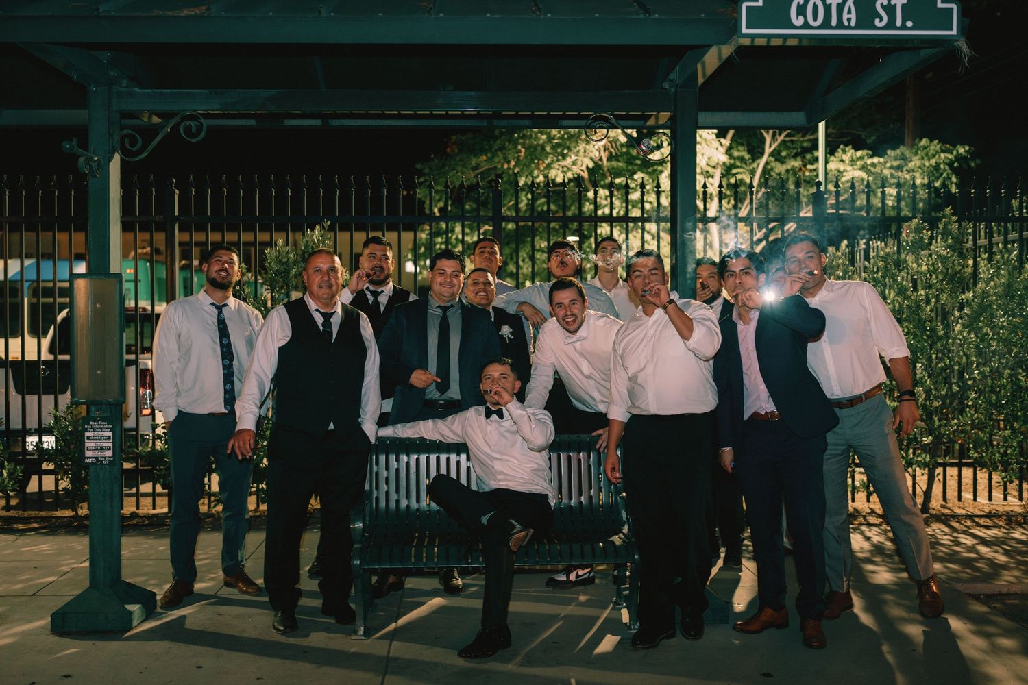 Group of groomsmen posing on Cota Street at night during a wedding celebration.